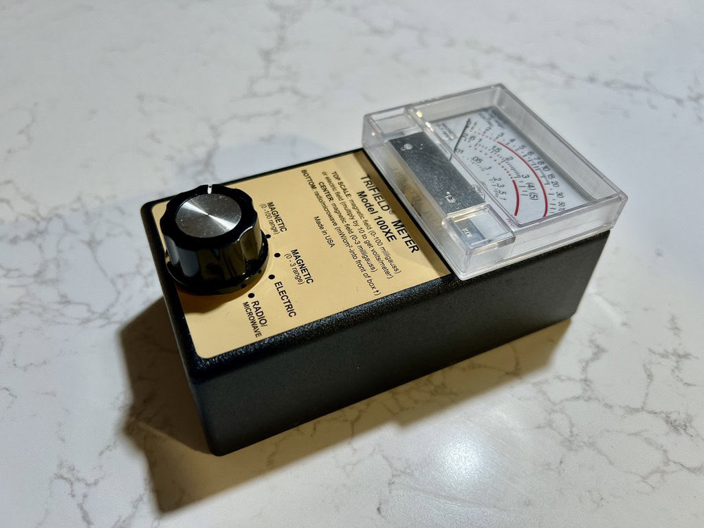 Trifield 100xe EMF meter on white marble background.