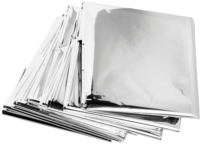 A stack of folded silver emergency blankets on a white background.