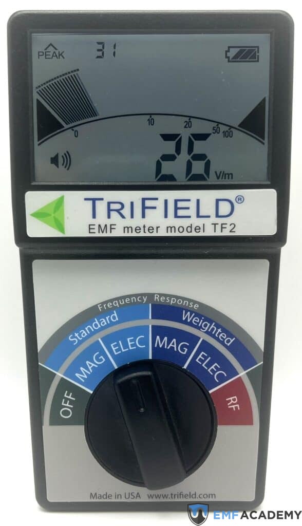 EMF meter displaying a reading of 26 V/m with settings for magnetic, electric, and radio frequency detection.