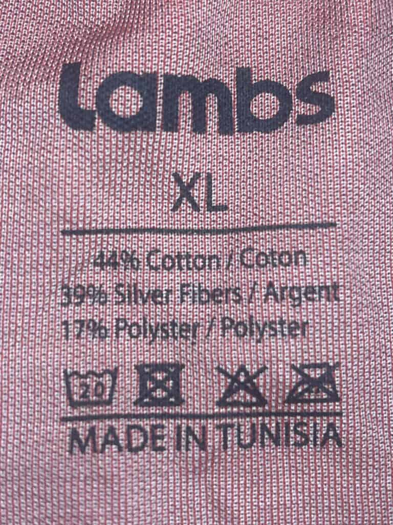 Close-up of a clothing label for a Lambs garment, size XL. The fabric is 44% cotton, 50% silver fiber, 7% polyester. Made in Tunisia, with washing symbols below.