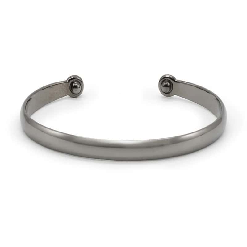 Metallic cuff bracelet with a smooth finish and open ends, featuring small round details at the ends, displayed against a white background.