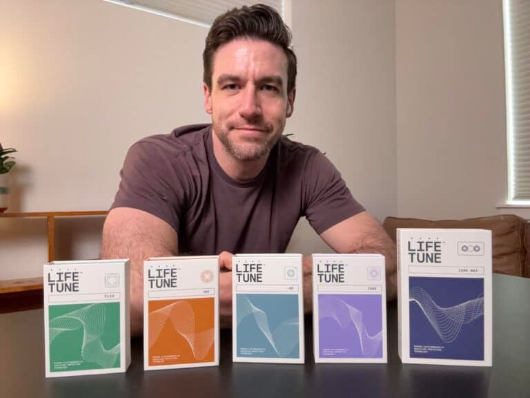 A person sits at a table with five Life Tune product boxes in front of them.