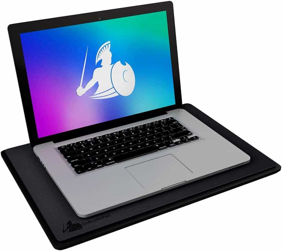 A laptop with a Spartan warrior logo on the screen, resting on a black cooling pad.