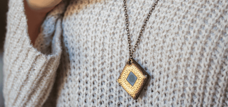 An Aires tech Lifetune Go, being worn as a necklace.