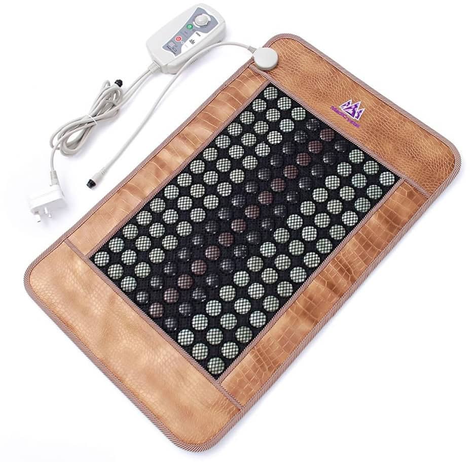 A heated massage pad with a brown border, black mesh center covered with round stones, and a white control unit with buttons and a power cord.