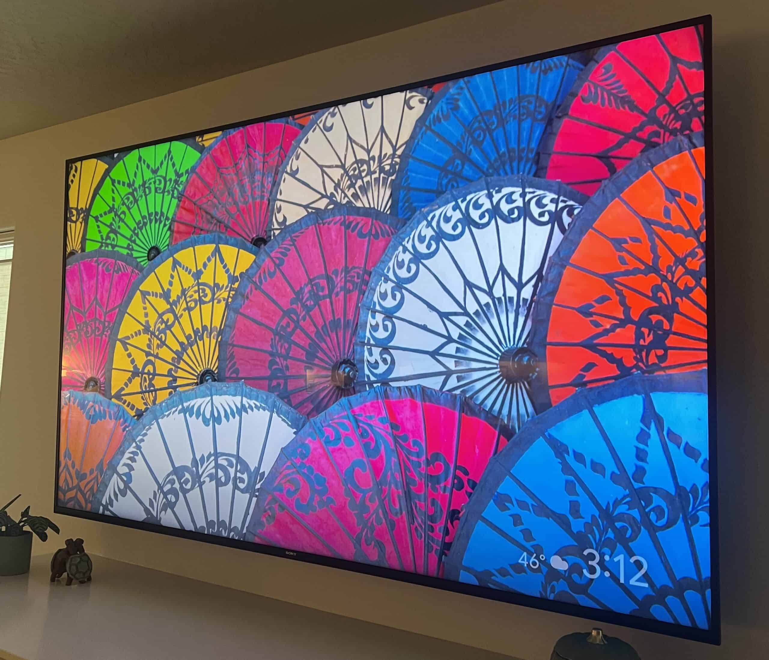 A television screen displays a colorful image of decorative handheld fans.