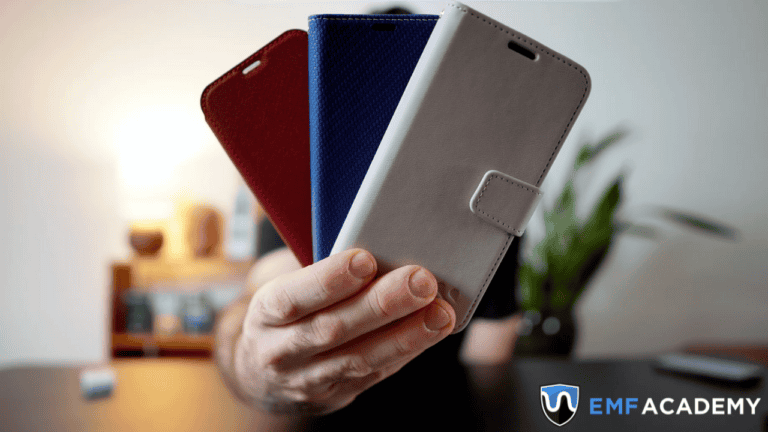 A person holds three smartphone cases in red, blue, and gray against a blurred background.