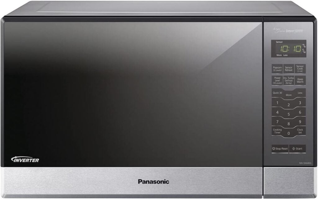 Silver Panasonic microwave with a digital display showing 10:10. The right side has a keypad with various cooking options and a handle-less door design.