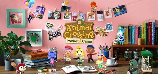 A colorful scene with Animal Crossing: Pocket Camp characters and decor on a desk, with art supplies, books, and photos hanging on a pink wall in the background.