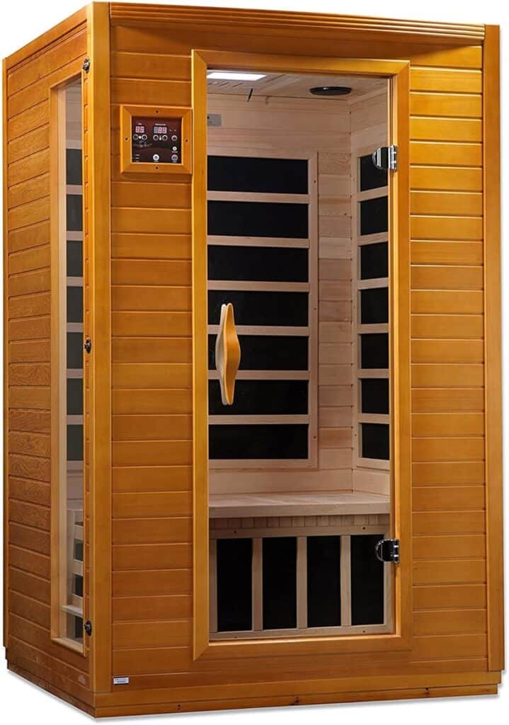 A standalone wooden infrared sauna with a glass door, interior bench seating, and digital control panel on the wall.
